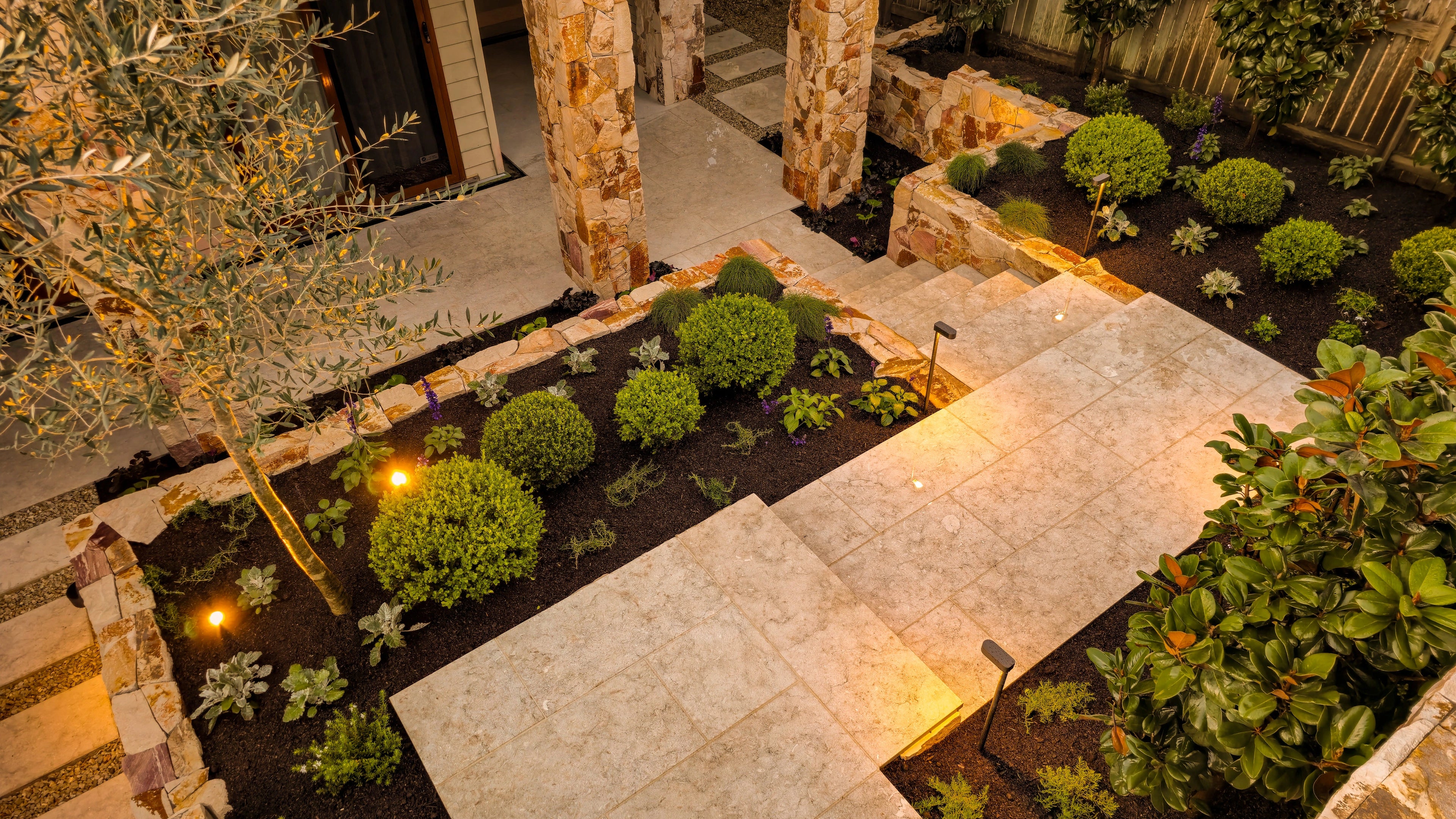 front garden featuring neutral coloured pavers and natural stone cladding.